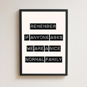 May include: A framed print featuring the text "REMEMBER IF ANYONE ASKS WE ARE A NICE NORMAL FAMILY" in a bold, black font. The text is arranged in a rectangular format on a cream background, within a black frame.