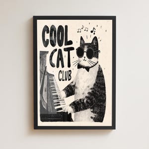 Può includere: Stampa artistica con cornice nera. Illustrazione in bianco e nero di un gatto con occhiali da sole e papillon, che suona il pianoforte. Note musicali fluttuano sopra il gatto. Testo: "COOL CAT CLUB".