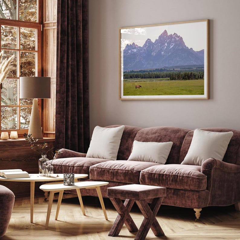 A stunning snow-covered mountain framed or unframed print from Grand Teton National Park with a beautiful horse grazing the grass in the forefront.