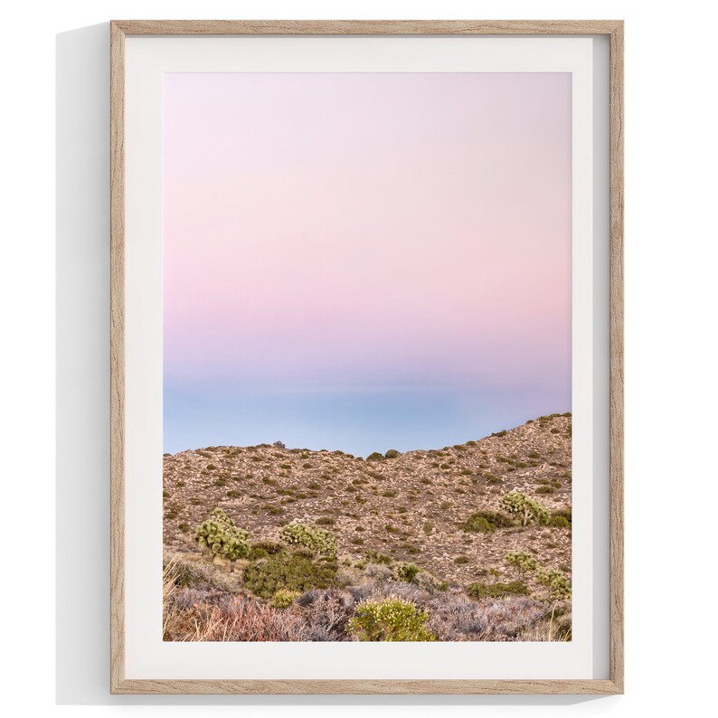 A wall art set of 3 framed or unframed Joshua Tree National Park prints.  This desert wall art showcases a stunning Joshua Tree and the desert terrain and plants in a breathtaking Pink sunset filled with Pink and Purple hues. Modern gallery wall set