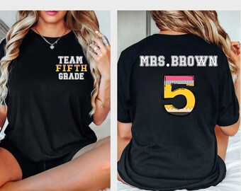 May include: Black t-shirt with the text "TEAM FIFTH GRADE" on the front and "MRS. BROWN" with a large number "5" designed as a pencil on the back.