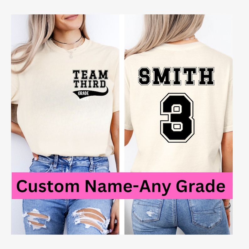 K&ouml;nnte beinhalten: Ein beiges T-Shirt mit schwarzem Text, der auf der Vorderseite "Team Third Grade" und auf der R&uuml;ckseite "Smith 3" lautet. Das Shirt wird von einer Person in blauer Jeans getragen.