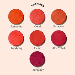 May include: A chart of seven different shades of red wood stain, labeled "Pomodoro", "Coral", "Terracotta", "Strawberry", "Flame", "Red Velvet", and "Burgundy". The chart is titled "Sloe Wood".