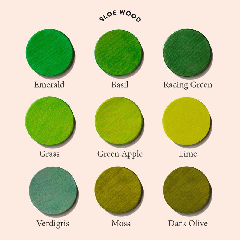 May include: Nine different shades of green paint swatches labeled with names like Emerald, Basil, Racing Green, Grass, Green Apple, Lime, Verdigris, Moss, and Dark Olive. The paint swatches are arranged in a grid of three rows and three columns. The text "SLOE WOOD" is written in a circle at the top of the image.