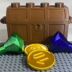May include: A brown wooden treasure chest with a gold keyhole, open to reveal two gems: a green one and a blue one.  There are also two gold coins with the number "20" on them.