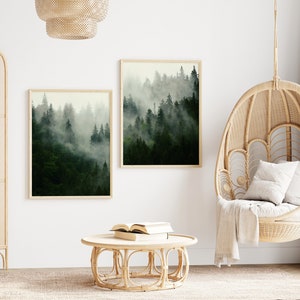 May include: Two framed prints of a misty forest scene hang on a white wall above a round wicker coffee table. A hanging wicker chair with a white cushion sits in the corner of the room.