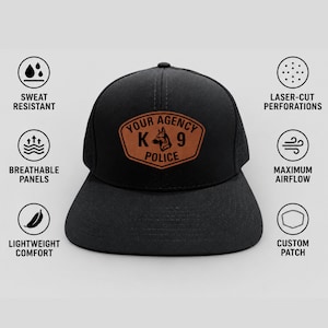May include: A black baseball cap featuring a brown leather-style patch on the front with the text YOUR AGENCY K9 POLICE and a dog silhouette. The cap includes side panels with laser-cut perforations for airflow, sweat resistance, and lightweight comfort.