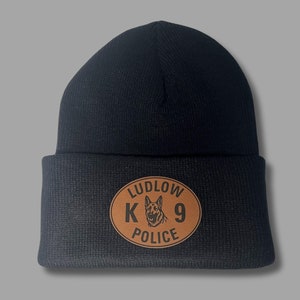 May include: Black knit beanie with a brown leather patch that says "LUDLOW K9 POLICE" with a German Shepherd silhouette.