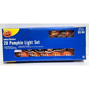 May include: A box of 20 orange pumpkin-shaped string lights for indoor or outdoor use. The lights are 11 feet long and have multiple wiring, so if one bulb goes out, the others stay lit. The box is blue and has a picture of the lights on it. The price is $3.94.