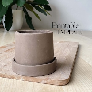May include: A brown ceramic planter with a matching saucer. The planter is sitting on a wooden cutting board. The text "Printable TEMPLATE" is visible in the image.