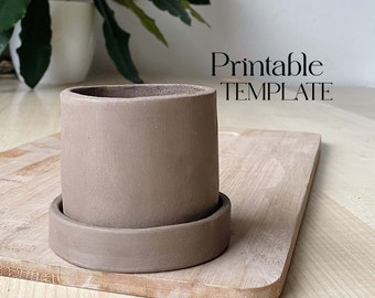 May include: A brown ceramic planter with a matching saucer. The planter is sitting on a wooden cutting board. The text "Printable TEMPLATE" is visible in the image.