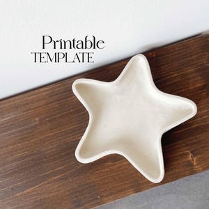 以下が含まれることがあります： 茶色の木製の表面に置かれた白いセラミック製の星型の皿。画像の左上隅に「Printable Template」というテキストが表示されています。