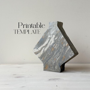 May include: Printable template for a geometric vase with a marbled gray, white, and gold design.