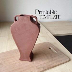 Op de afbeelding: Een terracotta kleivase met twee handvatten. De vaas staat op een houten snijplank. De tekst "Printable TEMPLATE" is zichtbaar boven de vaas.