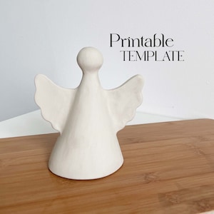 May include: Printable template for a white ceramic angel figurine. The angel has wings and a cone-shaped body.