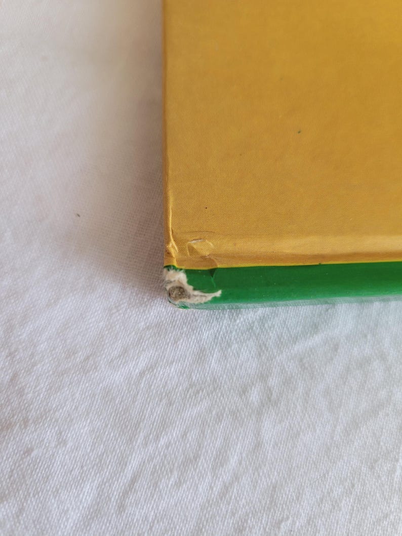 May include: A book with a yellow cover and a green spine. The book is slightly worn.