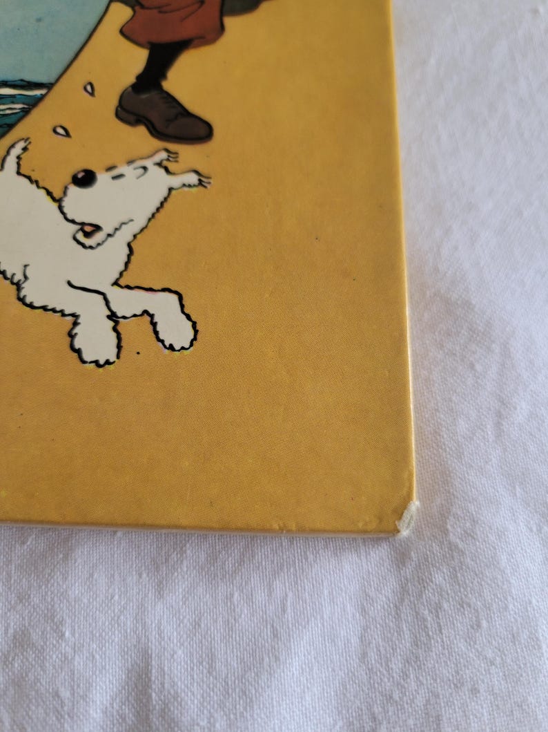 May include: A yellow book cover with a white dog running towards the right side of the page. The dog has black eyes and a black nose. The dog is on a yellow background with a few white dots.