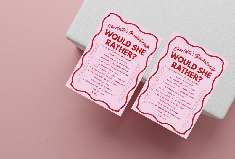 May include: Two pink cards with red text that says "Charlotte's Bachelorette Would She Rather?" with a list of questions to answer. The questions are in the format "Have a glass of wine or have a cocktail?" and "A facial or a massage?"