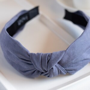 A close-up of a headband featuring a top knot detail in the color gray.