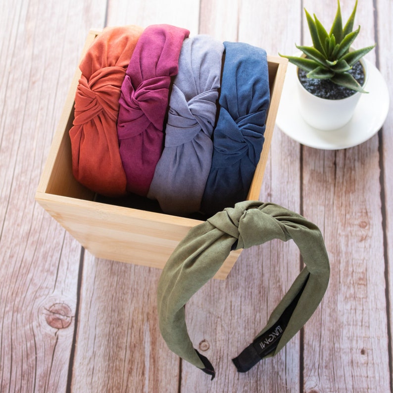 A collection of five headbands in the colors orange, purple, gray, blue, and green, respectively.