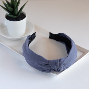 One headband featuring a top knot detail in the color gray.