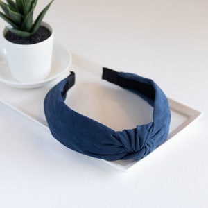 One headband featuring a top knot detail in the color blue.