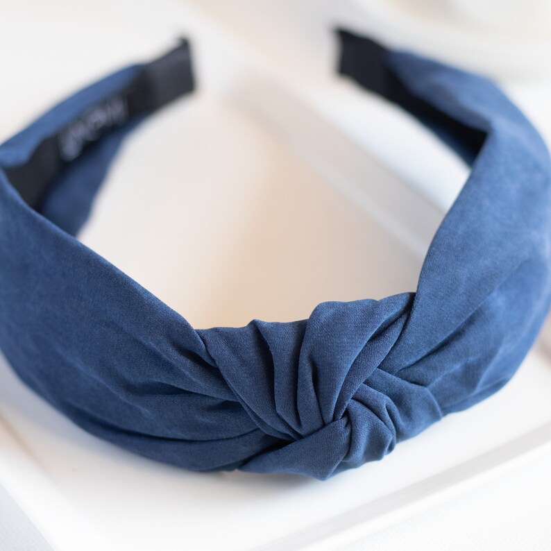 A close-up of one headband featuring a top knot detail in the color blue.