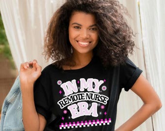 May include: Black t-shirt with the text "IN MY REMOTE NURSE ERA" in a pink and white design. The shirt has a daisy and star graphic. The shirt is a crew neck and has rolled-up sleeves.