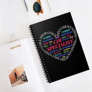 May include: A black spiral-bound notebook with the words "CDI Specialist" in a heart-shaped design. The design includes medical terms like "Nurse," "Diagnoses," and "Procedures." The notebook is on a white surface with sunglasses and a paper clip.