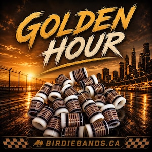 May include: A pile of golf club ferrules in white, brown, and black, with the words "GOLDEN HOUR" in gold. The background shows a sunset over a city skyline and the website address "BIRDIEBANDS.CA".