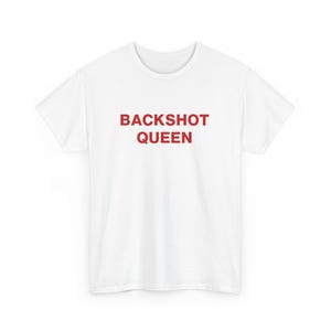May include: White t-shirt with the red text "BACKSHOT QUEEN" printed across the front. The shirt is a basic crew neck style, likely made of cotton or a similar fabric. The text is centered and bold.