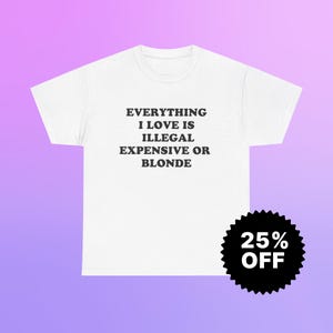 May include: White t-shirt with the text "EVERYTHING I LOVE IS ILLEGAL EXPENSIVE OR BLONDE" in black. A black and white circular sticker with "25% OFF" is in the lower right corner. The background is a gradient of purple and pink.