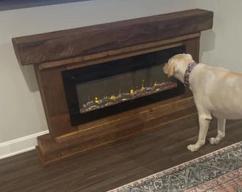 May include: A rustic wooden fireplace mantel with a built-in electric fireplace. A yellow Labrador Retriever dog is sniffing the fireplace.