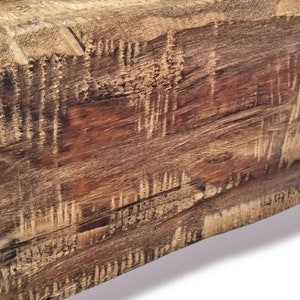 Puede incluir: Primer plano de una viga de madera r&uacute;stica con un acabado natural marr&oacute;n y marr&oacute;n claro. La madera tiene un aspecto desgastado con grano y nudos visibles.