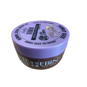 Può includere: Un barattolo di plastica viola e marrone di Ebin New York Argan Oil Edge Tamer con la scritta "Family Size" e "24 Hour Hold" sul coperchio.