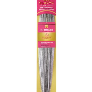 May include: A package of pre-stretched hair extensions in shades of gray and white. The packaging is pink and gold, with the brand name "SLAYYY" prominently displayed. The product is advertised as pre-stretched and featuring a special anti-itch treatment.