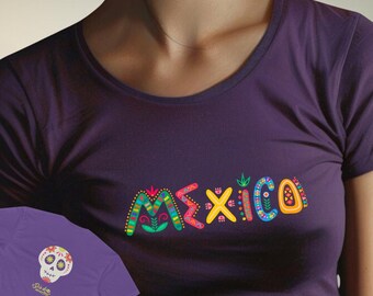 May include: A dark purple short-sleeved t-shirt featuring the word MEXICO in colourful, patterned, decorative lettering across the chest. A smaller graphic of a white sugar skull with floral details and the text Dia de Muertos is visible.