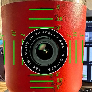 Puede incluir: Un vaso de acero inoxidable rojo con un gr&aacute;fico de lente de c&aacute;mara en blanco y negro y el texto "See the good in yourself and in others". El vaso tiene medidas marcadas en pulgadas.