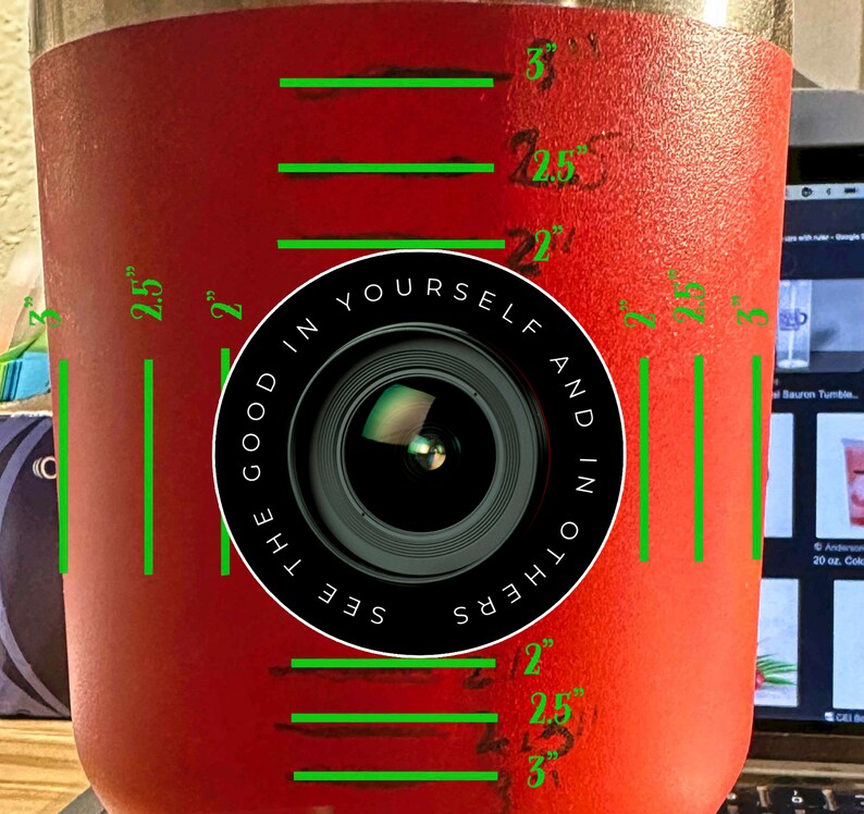 Puede incluir: Un vaso de acero inoxidable rojo con un gr&aacute;fico de lente de c&aacute;mara en blanco y negro y el texto "See the good in yourself and in others". El vaso tiene medidas marcadas en pulgadas.