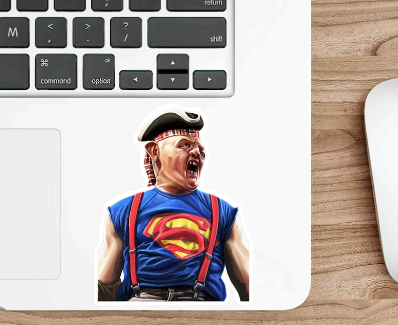 K&ouml;nnte beinhalten: Ein Aufkleber mit einer Comicfigur, die ein rot-blaues Superman-Kost&uuml;m, einen rot-wei&szlig; gestreiften Hut und rote Hosentr&auml;ger tr&auml;gt. Die Figur hat einen &uuml;berraschten Gesichtsausdruck und tr&auml;gt einen rot-wei&szlig; gestreiften Hut.