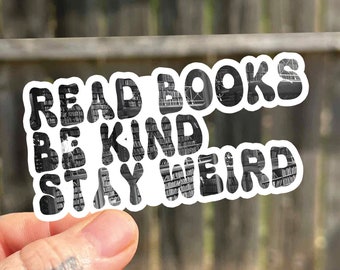May include: White sticker with the text "Read Books Be Kind Stay Weird" in black letters. The letters are made up of images of bookshelves.