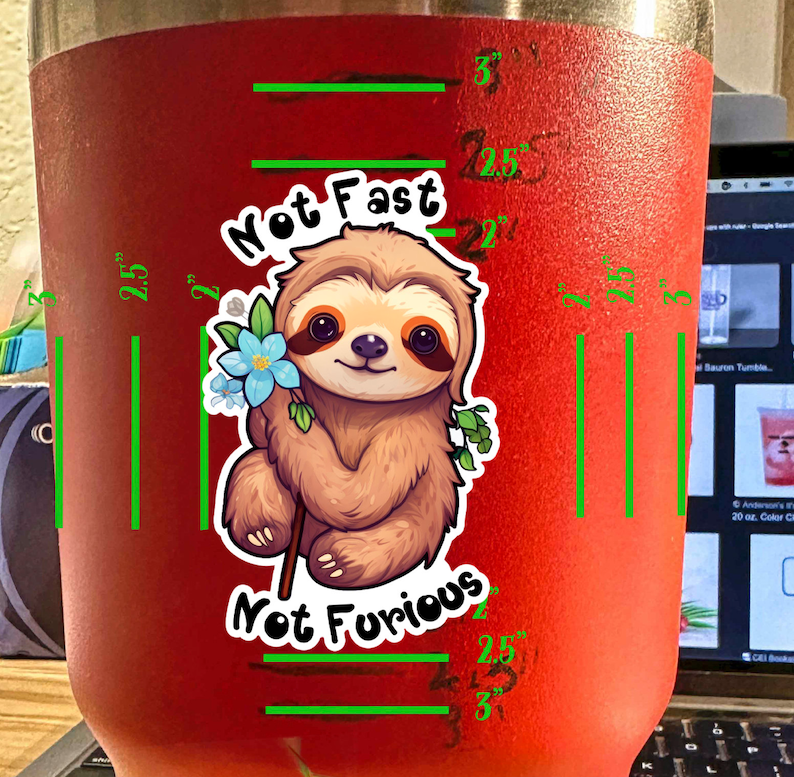 May include: Red stainless steel tumbler with a sloth cartoon graphic and the text "Not Fast Not Furious". The tumbler has a measurement scale in inches.