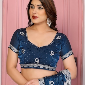 May include: A dark blue blouse with intricate silver embroidery and a matching shawl. The blouse features a scoop neckline and short sleeves with scalloped edges. The shawl has a detailed pattern.