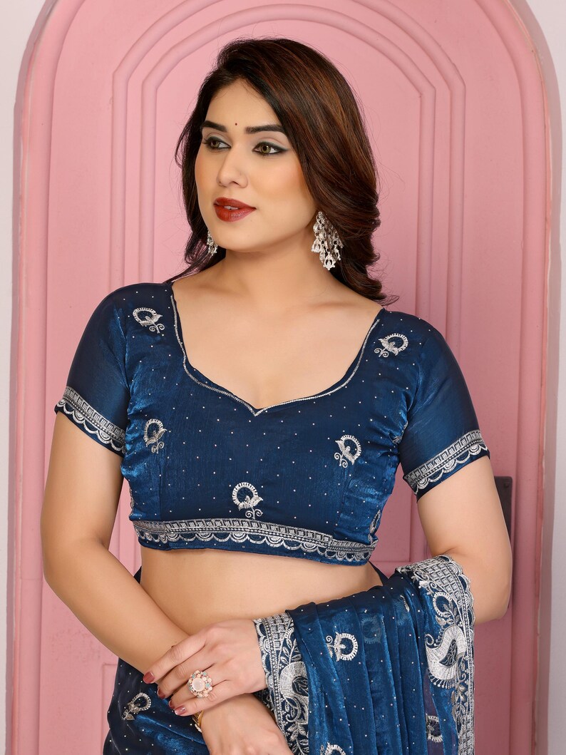 May include: A dark blue blouse with intricate silver embroidery and a matching shawl. The blouse features a scoop neckline and short sleeves with scalloped edges. The shawl has a detailed pattern.