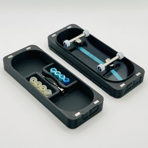 May include: A black fingerboard case with a compartment for wheels and a tool. The case also includes a fingerboard with blue and white wheels.