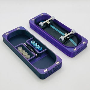 May include: A purple fingerboard case with a compartment for wheels and a tool. The case also includes a fingerboard with a black deck and blue grip tape.