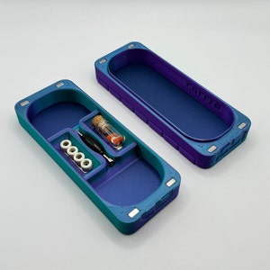 May include: A teal and purple plastic storage case with a small vial, a screwdriver, and four small wheels. The case has a magnetic closure and the text "COFFEE" is printed on the top.