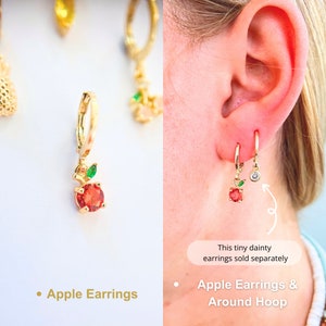 An apple hoop earrings. The red zirco with the fresh green leaf. meticulously crafted from high-quality 14K Gold-filled materials. These hoops exude elegance and playfulness, featuring designed apple charms add a touch of tropical joy to ensemble.
