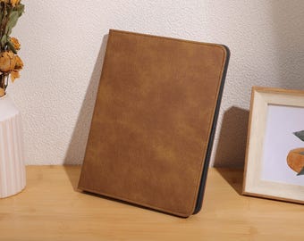 May include: A brown leather-like case with a textured surface. The case is closed and has a dark brown border.