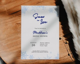 May include: A white bridal shower invitation with blue snowflakes and the text "Snow in Love" and "Maddison's Bridal Shower". The date is August 26th and the time is from 1-4pm. The invitation also includes the text "Kindly RSVP to Kathryn at 0400 123 456 before 12.05.2X".